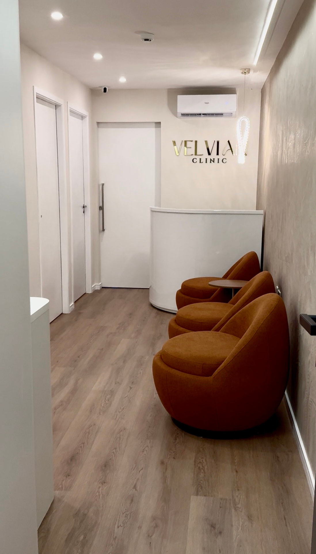 Recepção da clínica Velvian, com o letreiro dourado Velvian Clinic na parede